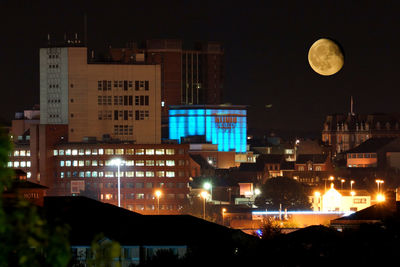 Illuminated cityscape against sky at night