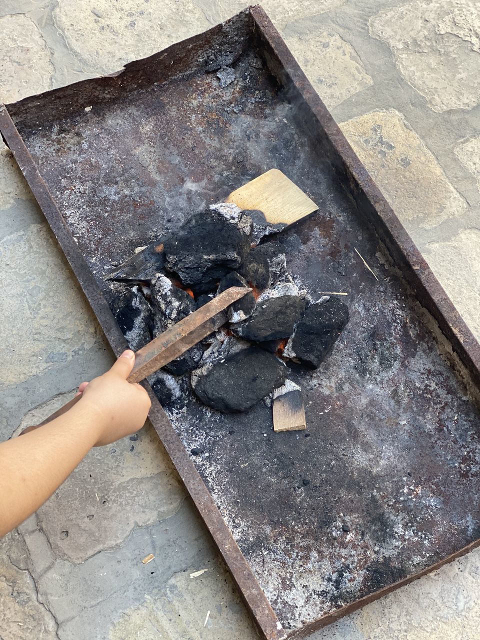 HIGH ANGLE VIEW OF PERSON HAND BY BONFIRE ON FLOOR