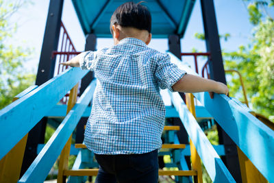 Rear view of boy on slide at playground