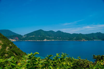 Scenic view of bay against blue sky