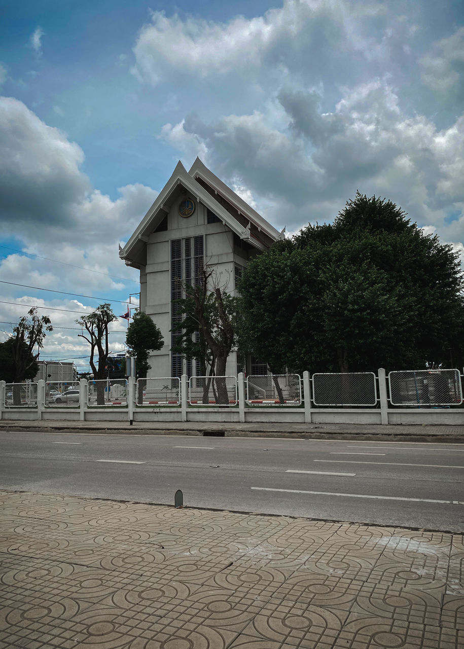 STREET BY BUILDING AGAINST SKY