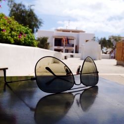 Close-up of sunglasses on house against sky