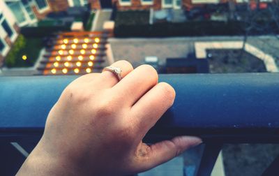 Close-up of cropped hand holding balcony railing