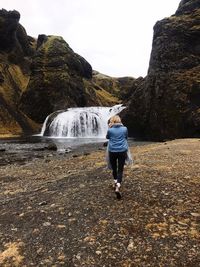 Rear view of man standing on rocks