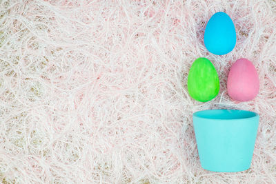 Directly above shot of bowl with colorful easter eggs on rug