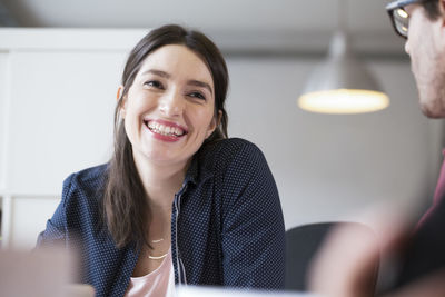 Smiling woman looking at man in office
