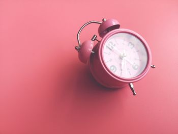 Close-up of clock on table against wall