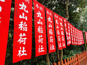 Close-up of information sign hanging on tree