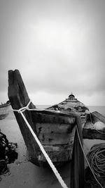 Boat moored on beach against sky