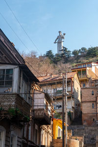 Statue of house and building against sky