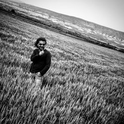 Tilt image of man standing on field against sky