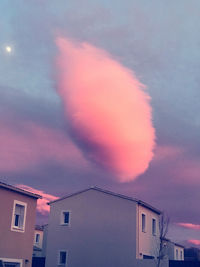 Low angle view of building against cloudy sky during sunset