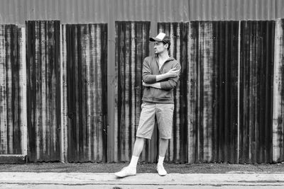 Portrait of man wearing hat standing against wall