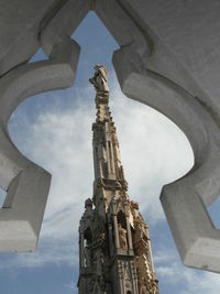 Low angle view of bell tower against cloudy sky