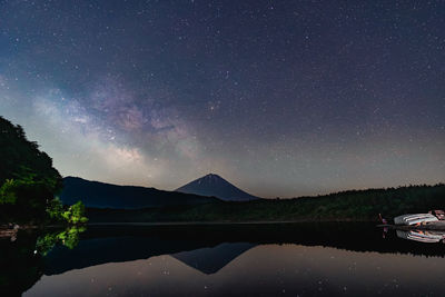 Scenic view of lake against sky at night