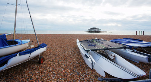 Small pleasure sailing boats dragged ashore on brighton's pebble beach. 