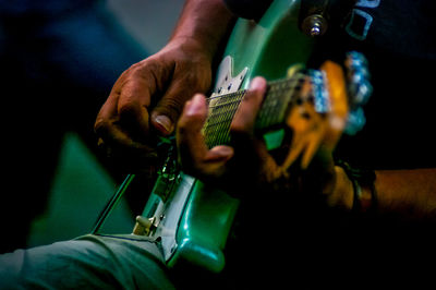 Midsection of man playing guitar