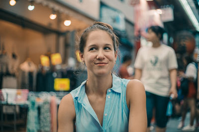 Smiling woman looking away while sitting outdoors