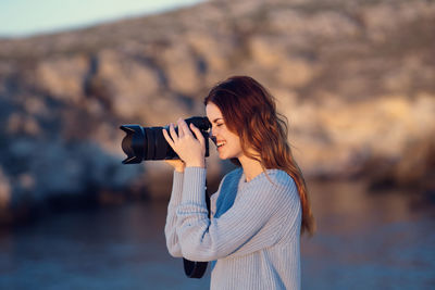 Side view of young woman standing outdoors