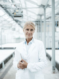 Smiling scientist standing in industry