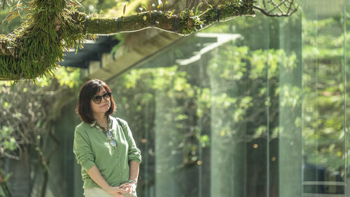 Portrait of woman standing by plants