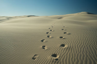 Sand dunes in desert against clear sky