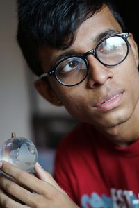 Close-up of young man holding globe