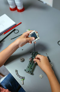 Female student connecting solar panel to electrical circuit in a robotics class