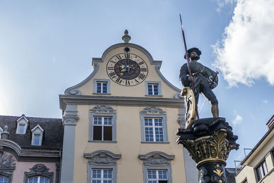 Low angle view of statue against building against sky