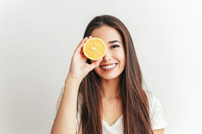 Portrait of a smiling young woman against white background