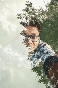 Portrait of young man seen through window with reflection