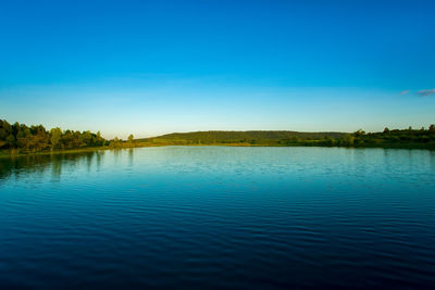 Scenic view of lake against clear blue sky