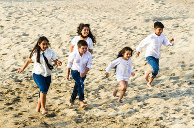 High angle view of children running on sand at beach