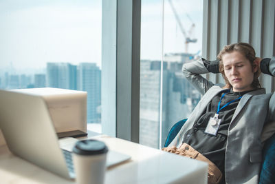 Young man looking at camera while sitting on table