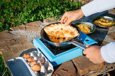 High angle view of people preparing food on camping stove