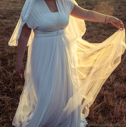 Midsection of woman standing on field