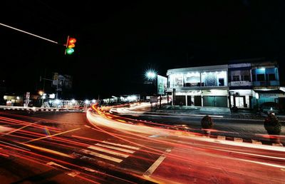 Light trails on road along buildings at night