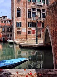 Bridge over canal by buildings in city