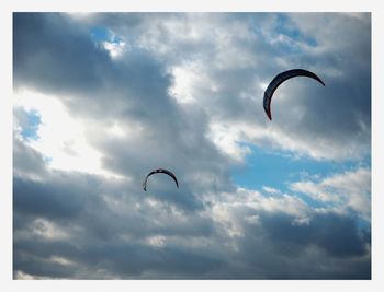 Low angle view of person paragliding against sky