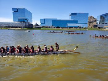 Group of people in river with buildings in background