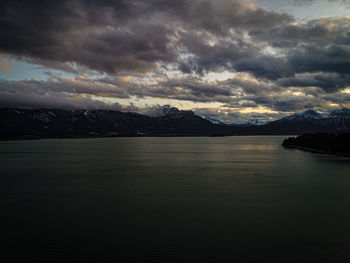 Scenic view of lake by mountains against sky