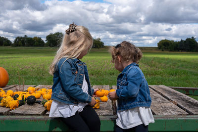 Rear view of mother and daughter against sky