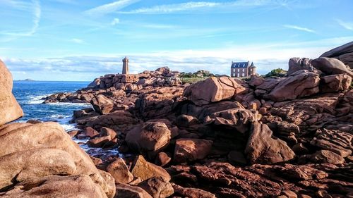 Rocks by sea against sky