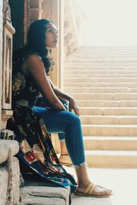 Young woman sitting on staircase