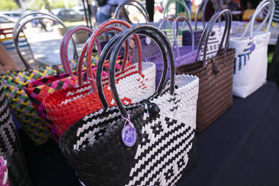 Close-up of multi colored clothes hanging on wicker basket for sale