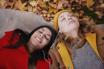 Friends lying on ground in autumn scenery