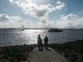 People on sea against sky