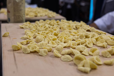 Freshly prepared uncooked pasta on a wooden cutting board- pasta of the italian orecchiette type.