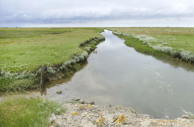 Scenerywith water canal at a hallig named nordstrandischmoor at the north frisian coast in germany