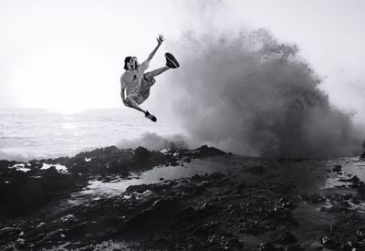 Low angle view of woman jumping on beach